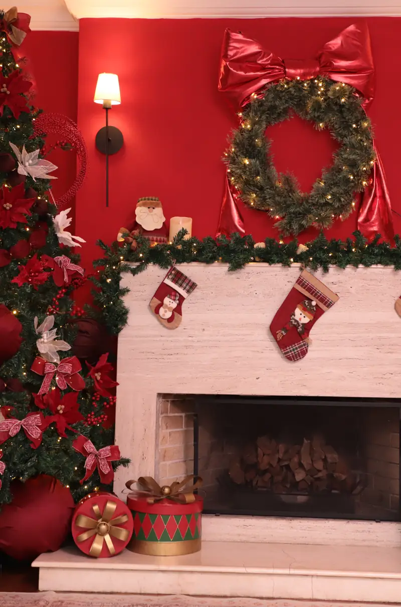 Piano antigo com grande laço vermelho e árvores de Natal no cenário vermelho do Loft Oásis