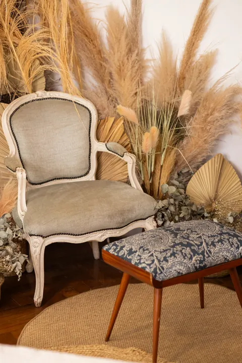 Poltrona clássica, banqueta estampada e plumas de capim-dos-pampas no Estúdio Majestic