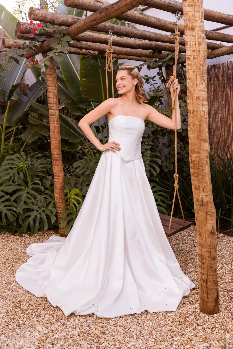 Noiva de vestido tomara que caia sob o pergolado do jardim da Mansão Eventual, ao lado do balanço