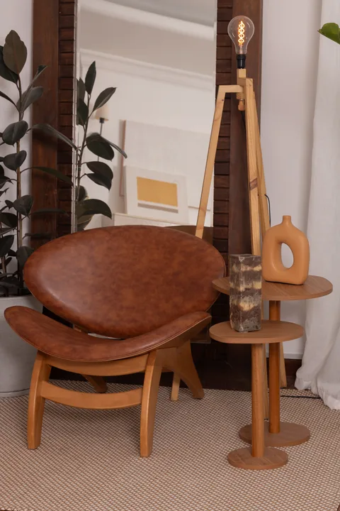 Poltrona de couro caramelo com mesa lateral e luminária de tripé