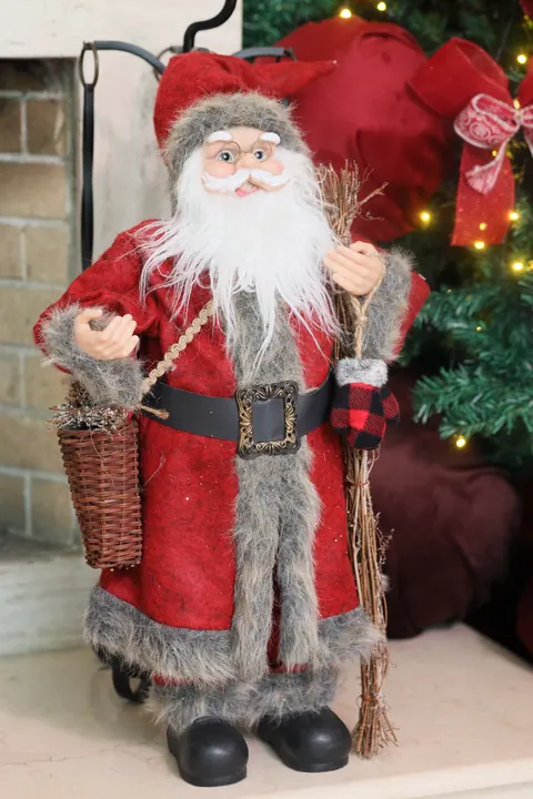Boneco de Papai Noel com casaco vermelho ao lado das árvores no cenário de Natal do Loft Oásis