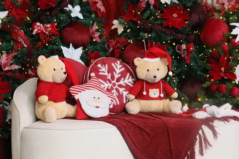 Ursinhos de pelúcia e almofada de Papai Noel sobre a poltrona branca no Natal do Loft Oásis
